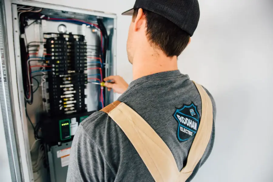 RooHam electrician working at an electrical panel